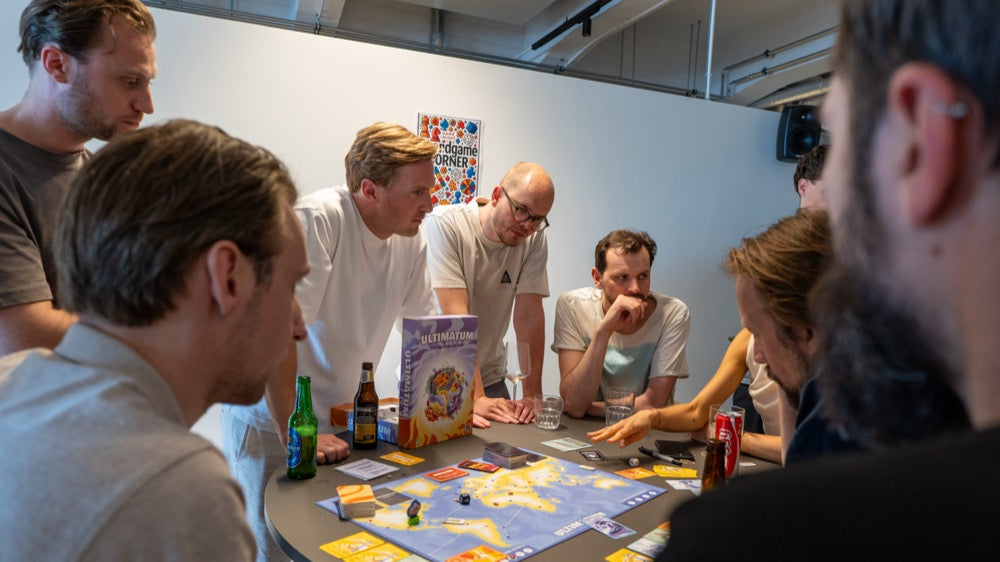 Een groep spelers staat over het bord gebogen en overlegt de volgende zet